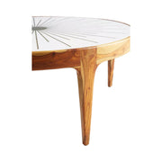 Side view of brass starburst coffee table with intricate round design